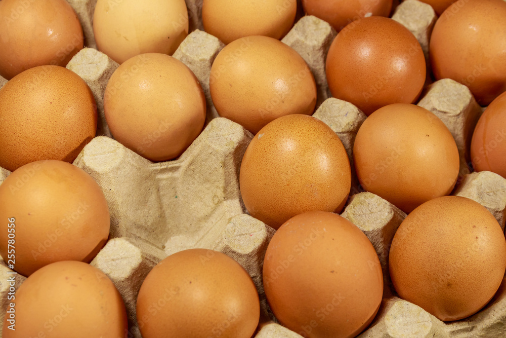 Raw chicken eggs in cardboard egg box with empty space Raw chicken eggs in cardboard egg box with empty space