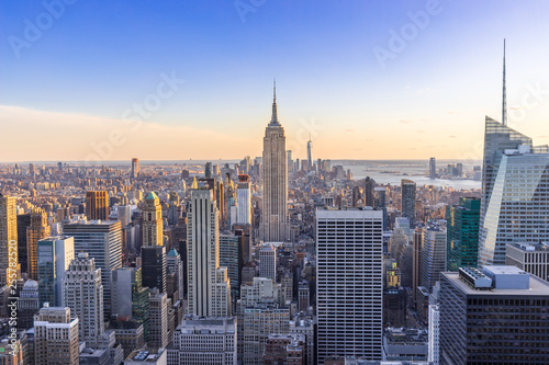 New York City Skyline in Manhattan downtown with Empire State Building and skyscrapers at sunset USA © Worawat