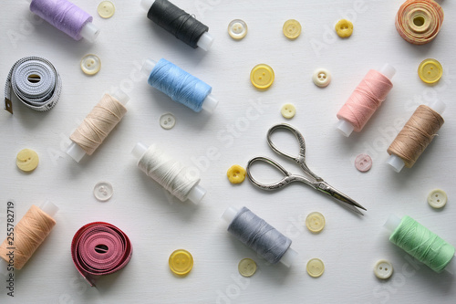 Composition with threads and sewing accessories on a white background, flat lay