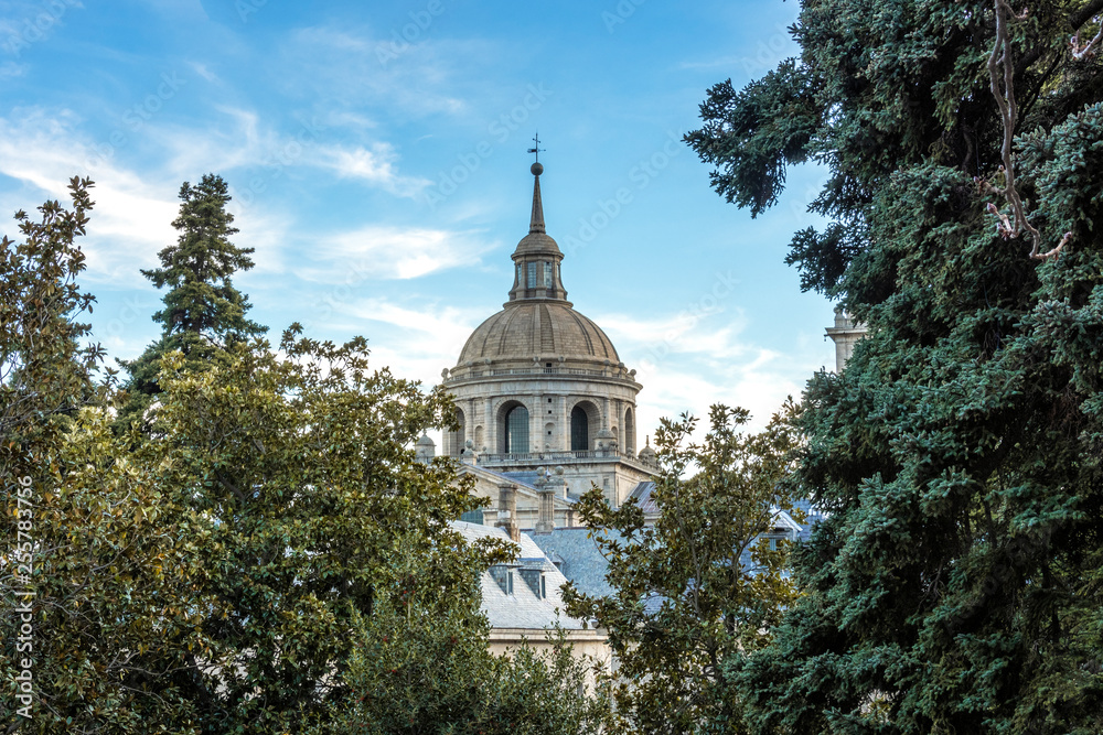 View of a dome of the Escorial monastery surrounded by trees. Spain madrid.