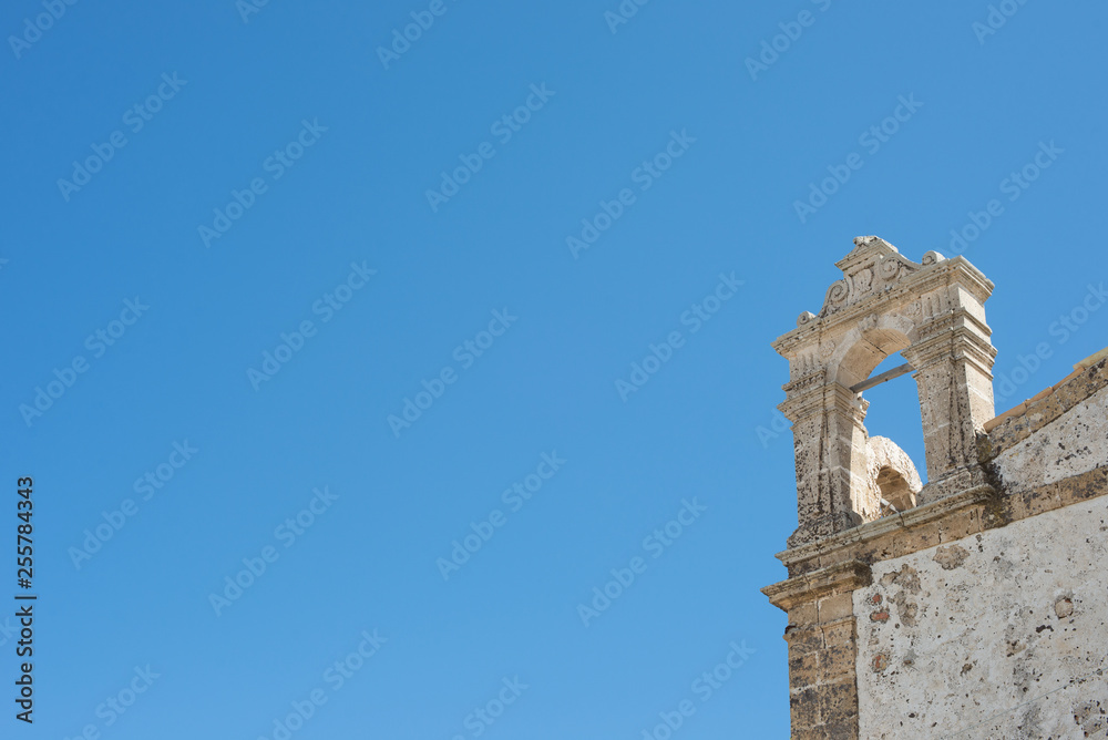 Detail of an ancient building dating back to the 17th century on an all-blue sky, with lots of copyspaces.