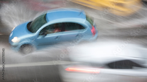 Rainy day in the city: Driving cars in the street hit by the heavy rain with hail in dangerous situation