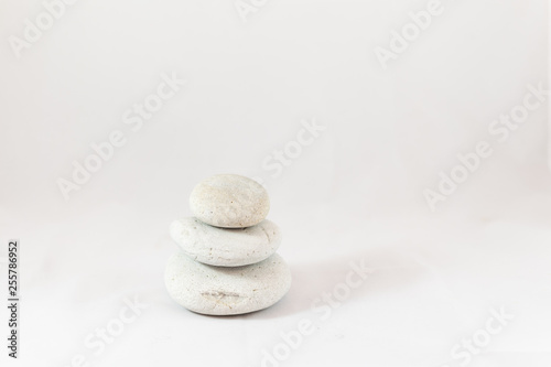 Three smooth pebbles stacked with white background