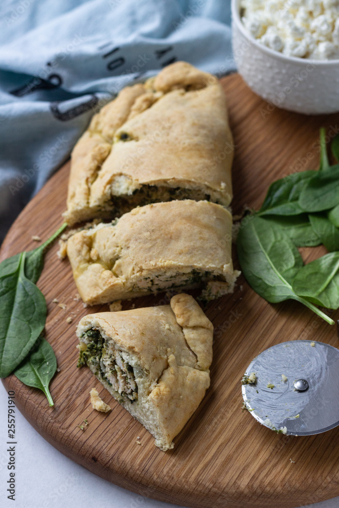 Fototapeta premium Closed pizza calzone with spinach, chicken and ricotta. Italian food.