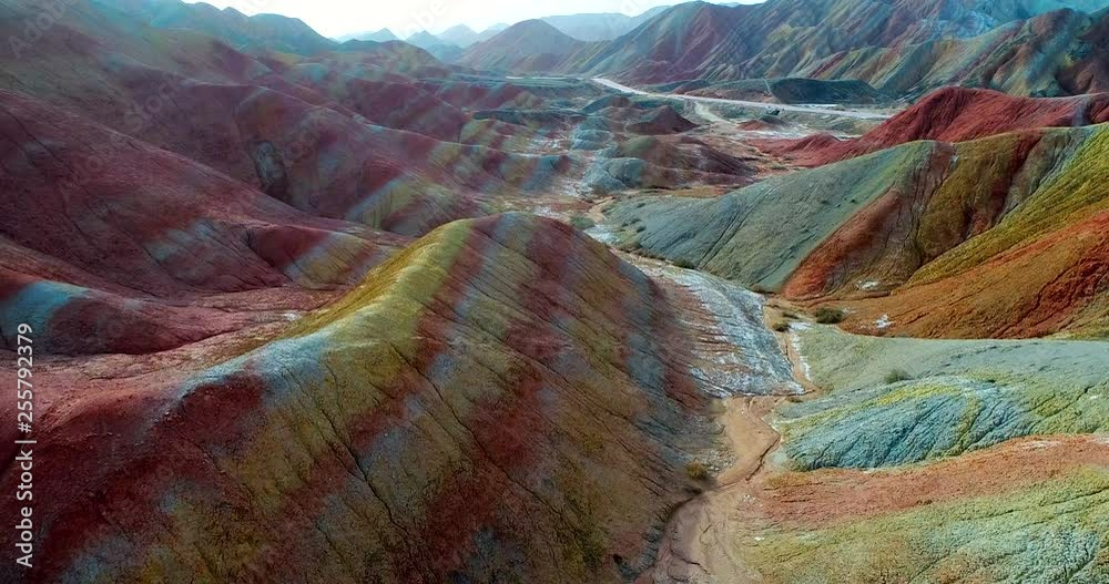 Aerial rainbow mountain landscape in 4k. Drone footage showing the most beautiful valley in Zhangye National Geopark, with sandstone hills covered by colorful pattern. Zhangye Danxia, Gansu, China.