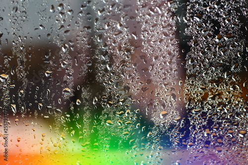 Abstract blurred colorfull rainbow aurora borealis on window glass with raindrops with multicolored lights with free copy space for text