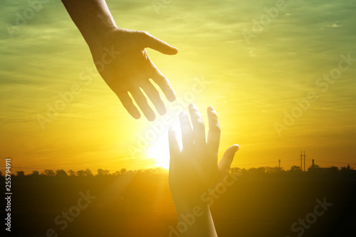 Man reaching for woman's hand at sunrise outdoors, closeup. Help concept