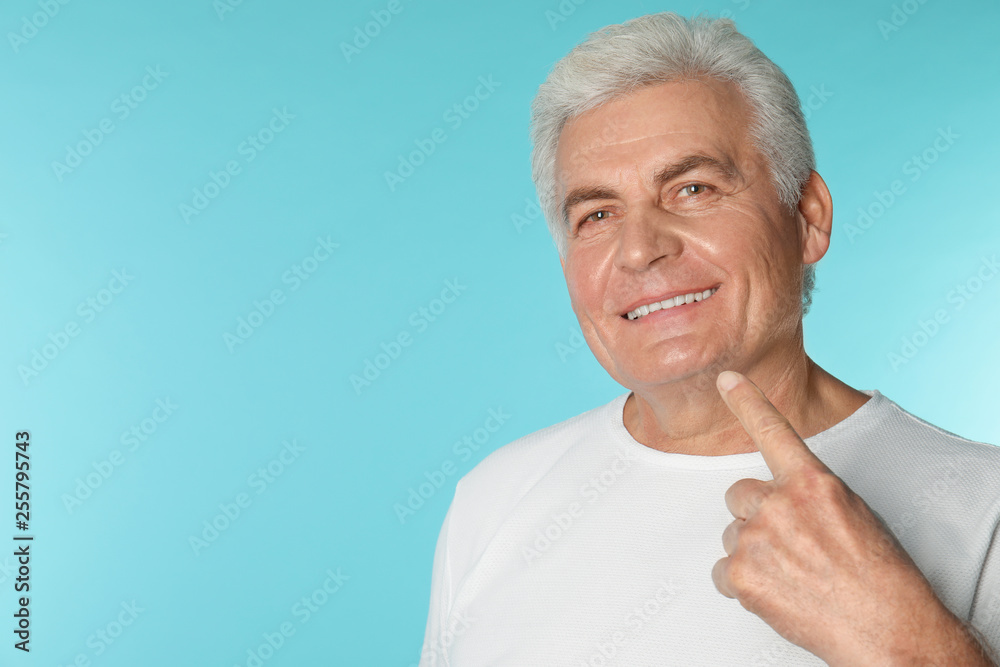Mature man with healthy teeth on color background. Space for text Mature man with healthy teeth on color background. Space for text