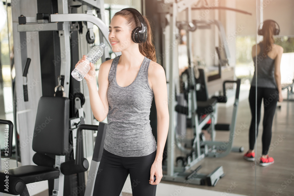 Pretty young sport woman is drinking water in gym, Healthy lifestyle Pretty young sport woman is drinking water in gym, Healthy lifestyle
