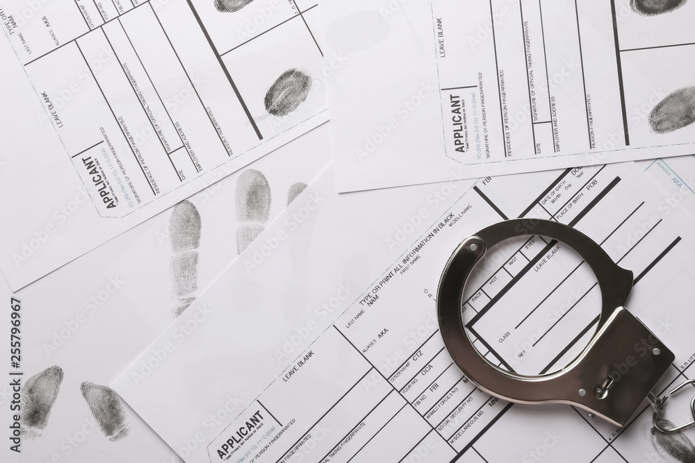Handcuffs and fingerprint record sheets, top view. Criminal investigation Handcuffs and fingerprint record sheets, top view. Criminal investigation