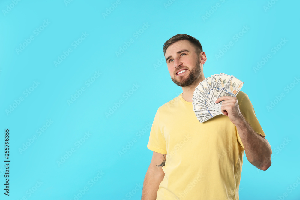 Portrait of happy young man with money on color background. Space for text Portrait of happy young man with money on color background. Space for text