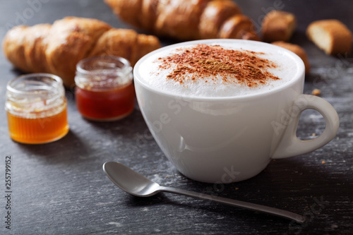 cup of cappuccino coffee on dark table