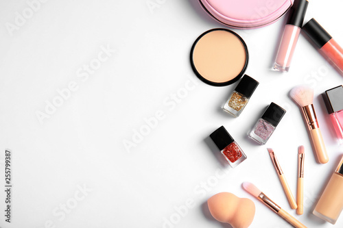 Flat lay composition with bottles of nail polish and different cosmetics on white background