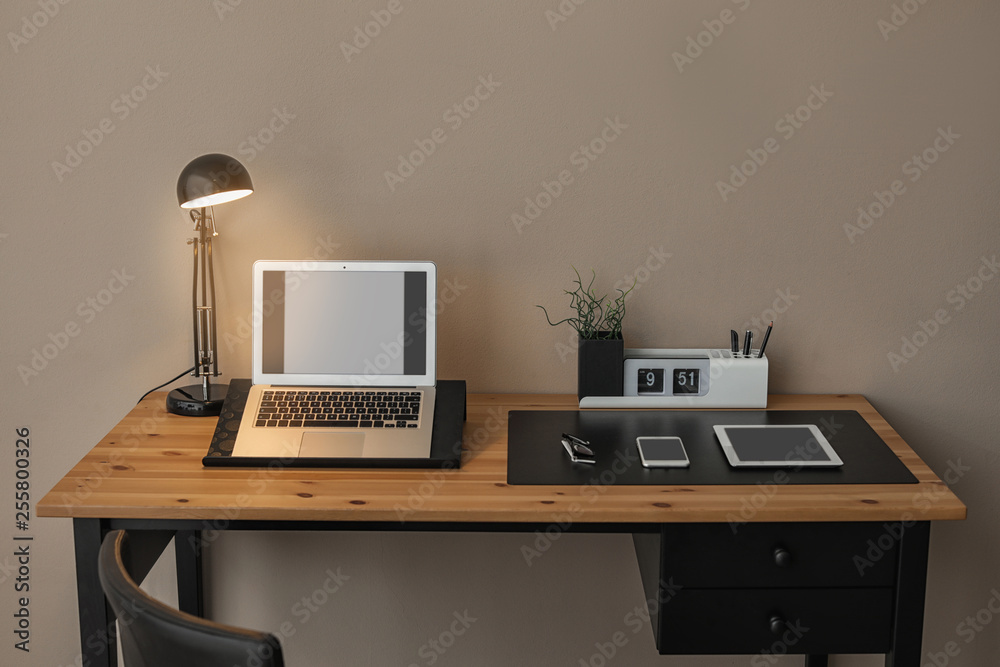 Modern workplace interior with laptop and devices on table. Space for text Modern workplace interior with laptop and devices on table. Space for text