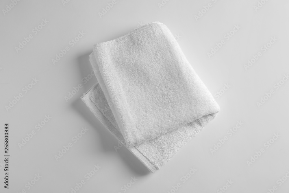 Fototapeta premium Folded soft terry towel on light background, top view