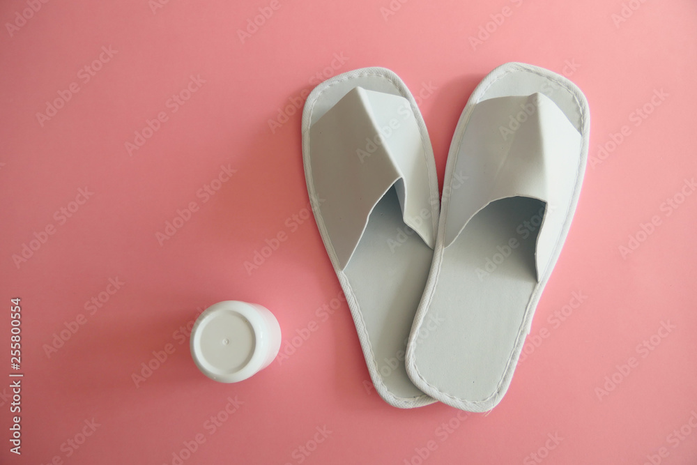 White Spa Slippers with a White Cream Box isolated on Pink Background White Spa Slippers with a White Cream Box isolated on Pink Background