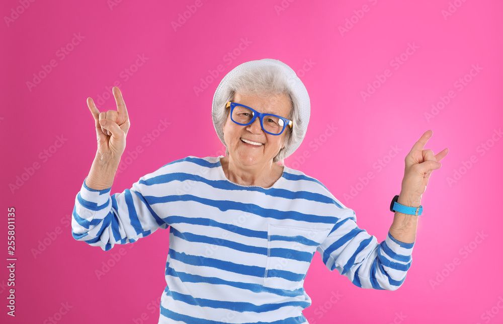 Naklejka premium Portrait of cool grandmother on color background