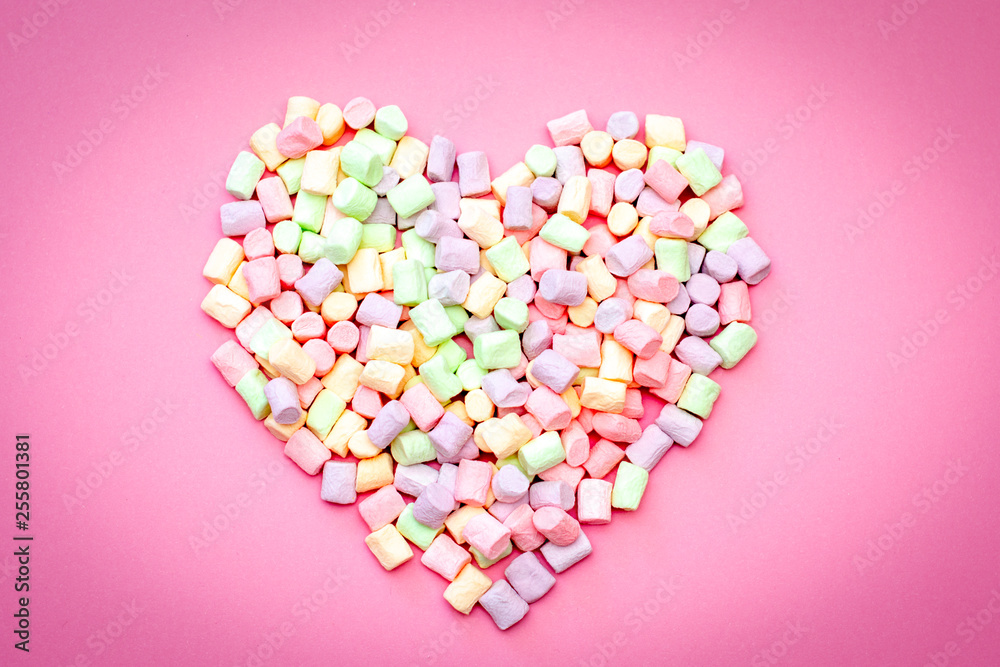 Air delicious romantic heart of tender multi-colored marshmallow on a pink background