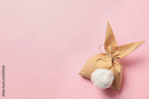 Creative Easter bunny gift bag on color background, top view with space for text