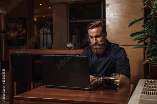 Bearded businessman working on his laptop