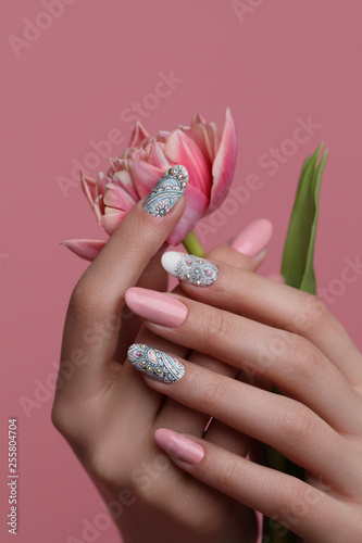 Nails  Art Design. Hands With pink Manicure On pink Background. Close Up Of Female Hands With Trendy pink Nails with spring flower. 