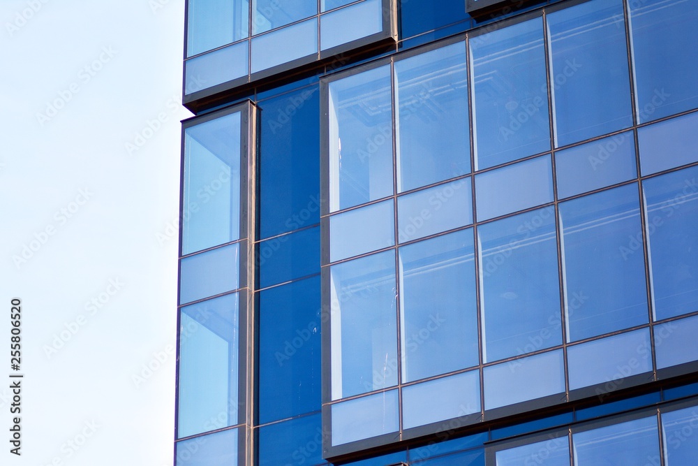 New office building in business center. Wall made of steel and glass with blue sky. New office building in business center. Wall made of steel and glass with blue sky.
