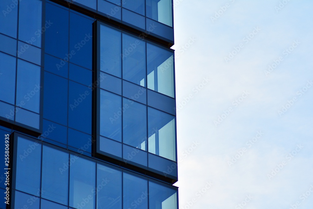 New office building in business center. Wall made of steel and glass with blue sky. New office building in business center. Wall made of steel and glass with blue sky.