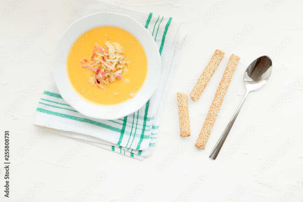 Pumpkin soup and organic pumpkins, top view, copy space. Seasonal autumn food - Spicy pumpkin soup with croutons and pumpkin seeds.