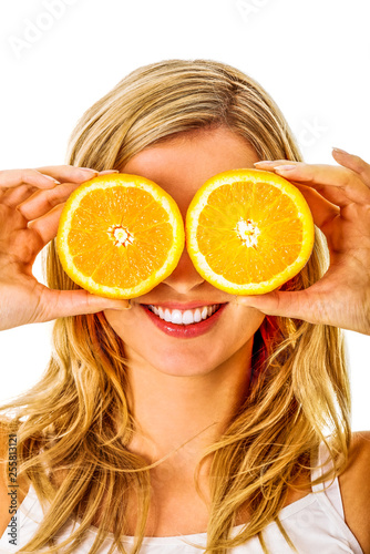 Blond woman is covering eyes by two half of orange fruit, on white background.