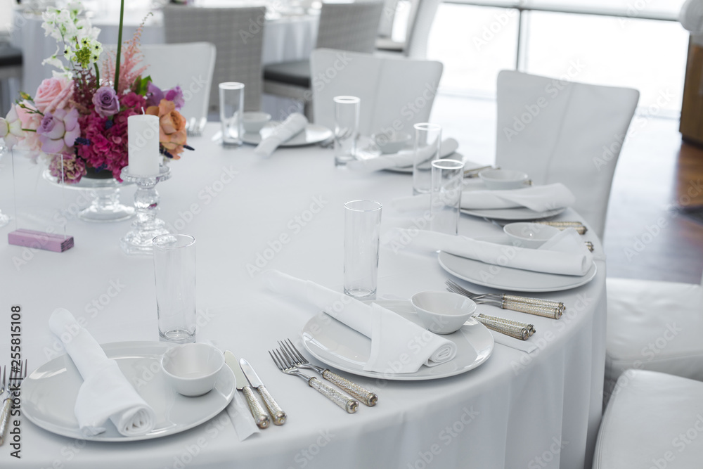 Fototapeta premium served table in the restaurant. clean white dishes layout on a white tablecloth