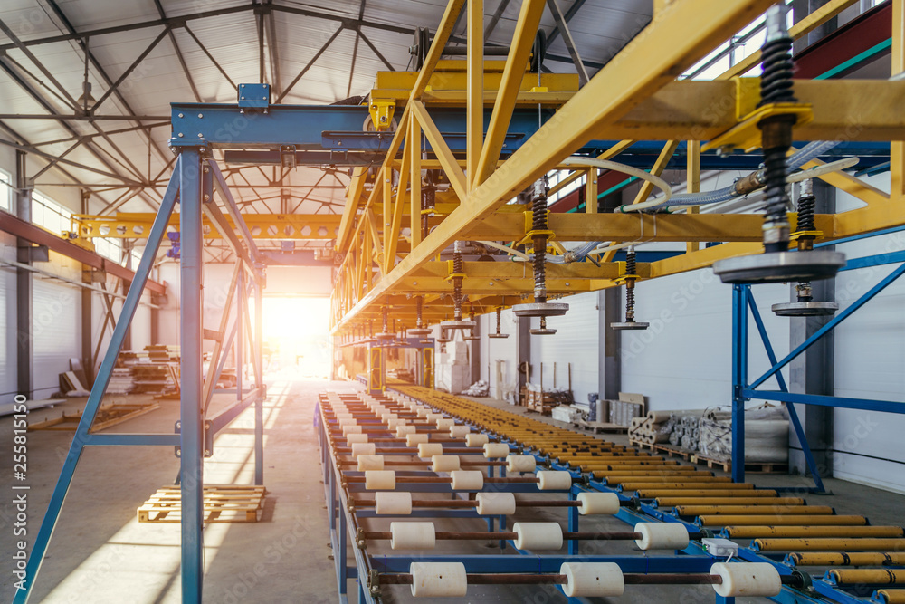 Modern thermal insulation sandwich panel production line. Machine tools, roller conveyor and overhead crane in workshop