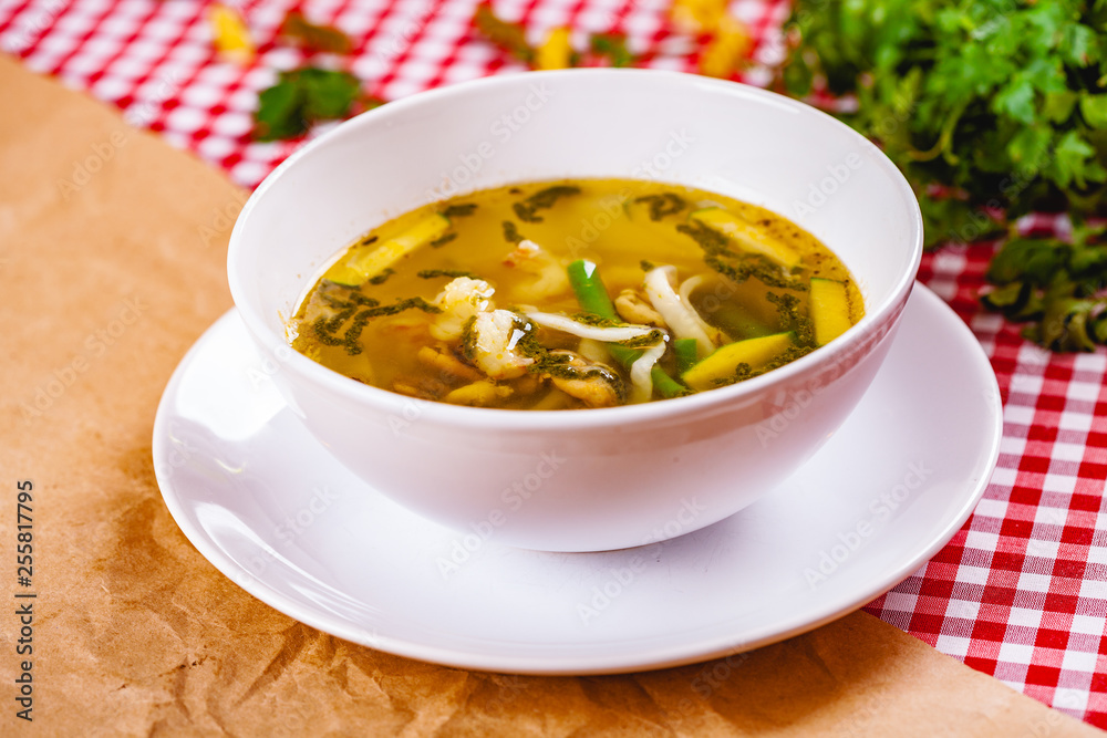 Soup with vegetables and seafood in white bowl. Close up Soup with vegetables and seafood in white bowl. Close up