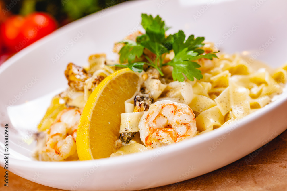 Italian pasta with seafood on white plate. Close up Italian pasta with seafood on white plate. Close up
