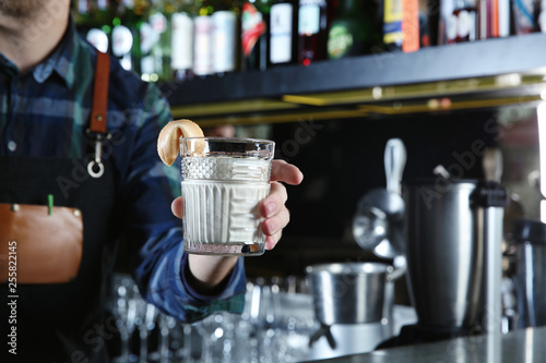 Barman holding White Russian cocktail in night club, closeup. Space for text © New Africa