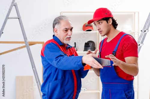 Two professional contractors laying flooring at home 