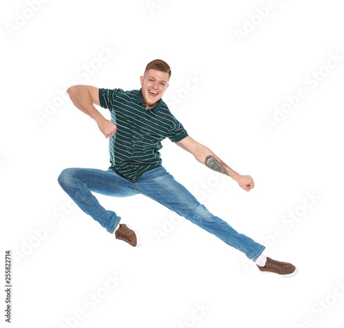 Handsome young man jumping on white background