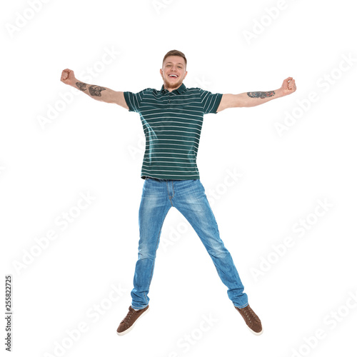 Handsome young man jumping on white background
