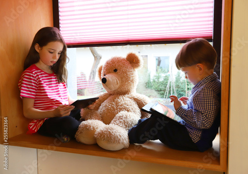 Ein kleiner Junge und ein Mädchen spielen auf einem ipad