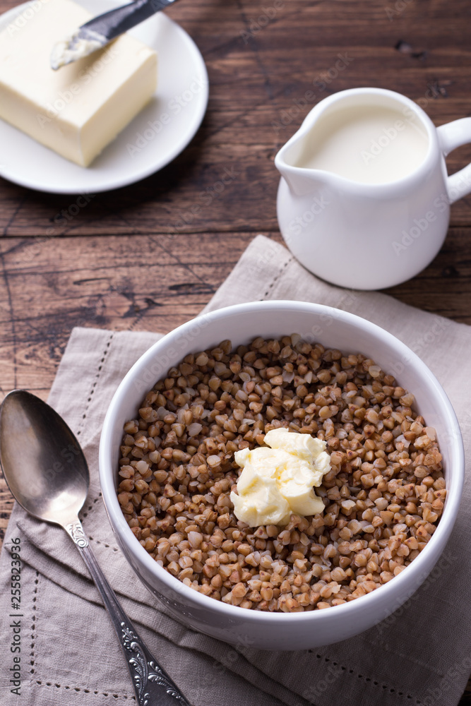 Buckwheat porridge with milk and butter on a wooden table Buckwheat porridge with milk and butter on a wooden table