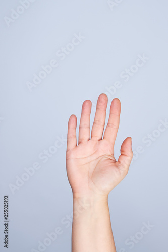 female hand raised up on a white background