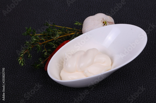 Mayonnaise sauce in the white bowl served thyme and garlic