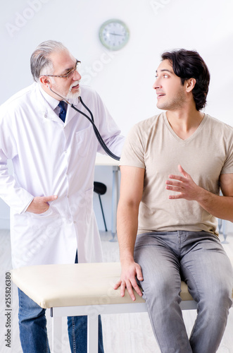 Young male patient visiting old doctor 