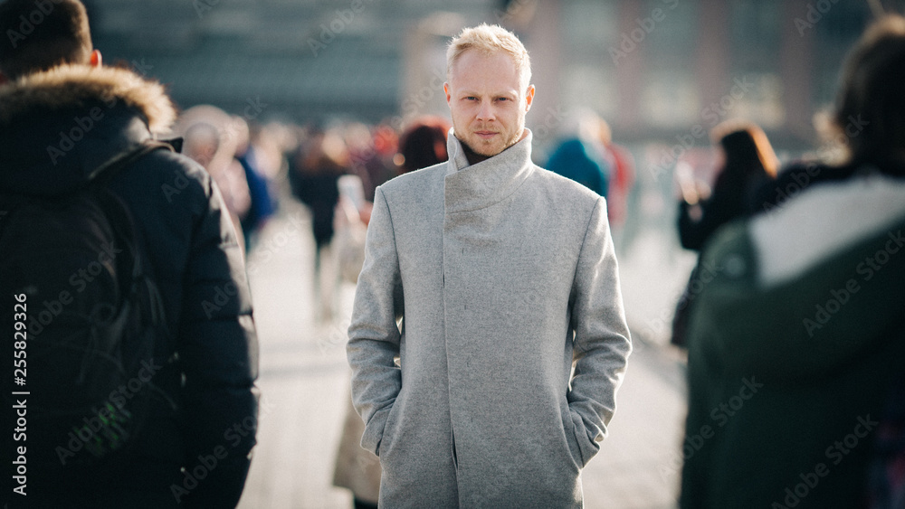Photo of blond in gray coat in city. Photo of blond in gray coat in city.