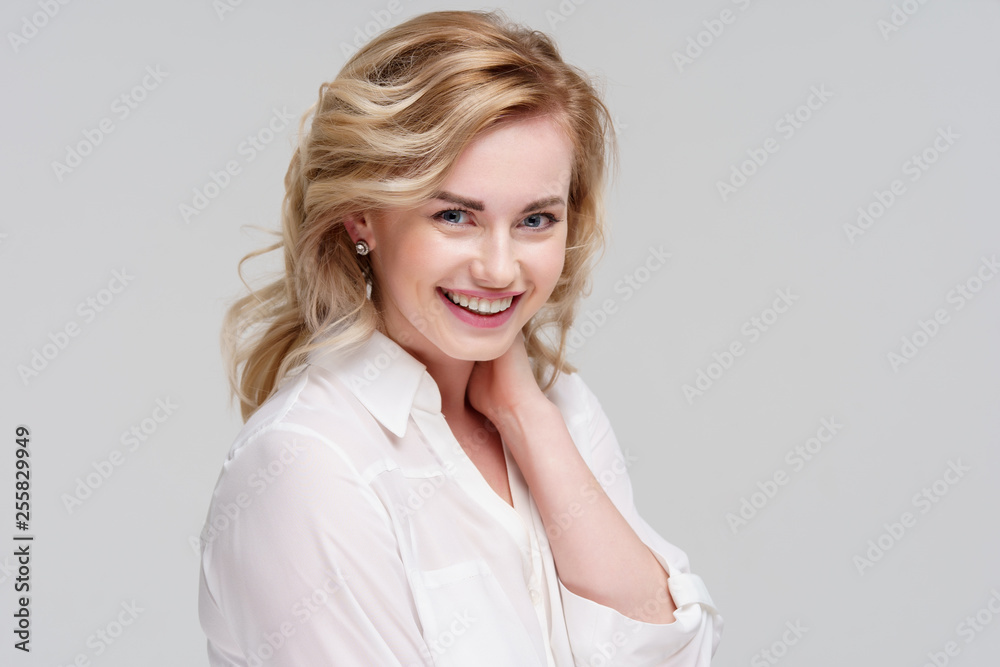 Portrait of smiling curly woman in white shirt in studio. Portrait of smiling curly woman in white shirt in studio.