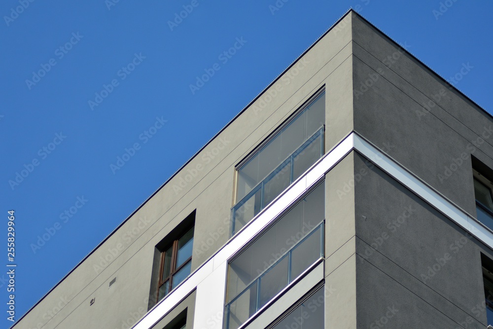 Multistory new modern apartment building. Stylish living block of flats. Modern, new executive apartments and with deep blue summer sky Multistory new modern apartment building. Stylish living block of flats. Modern, new executive apartments and with deep blue summer sky