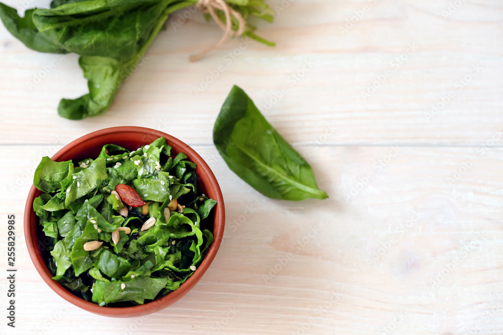 Vegan spinach salad on a light wooden background Vegan spinach salad on a light wooden background