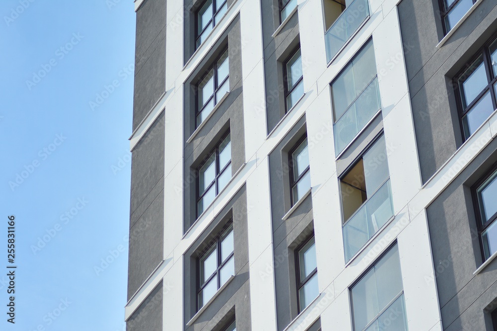 Multistory new modern apartment building. Stylish living block of flats. Modern, new executive apartments and with deep blue summer sky Multistory new modern apartment building. Stylish living block of flats. Modern, new executive apartments and with deep blue summer sky