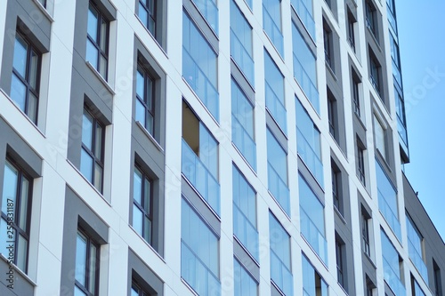 Multistory new modern apartment building. Stylish living block of flats. Modern, new executive apartments and with deep blue summer sky