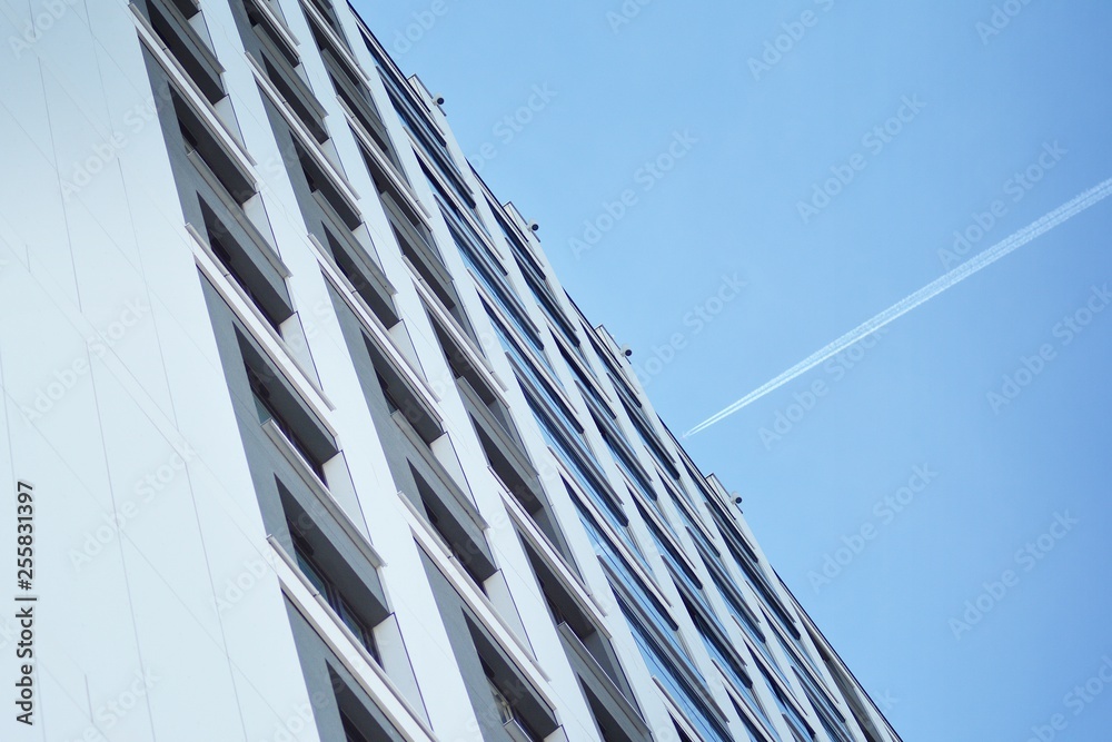 Multistory new modern apartment building. Stylish living block of flats. Modern, new executive apartments and with deep blue summer sky Multistory new modern apartment building. Stylish living block of flats. Modern, new executive apartments and with deep blue summer sky