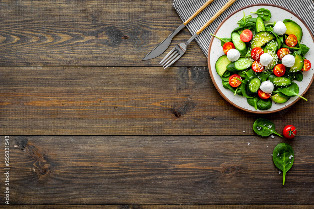 Vegetarian meal. Fresh vegetable salad on dark wooden background top view copy space